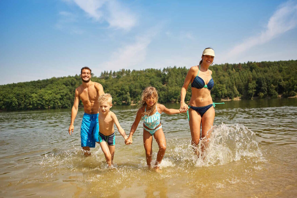 Familie und zwei Kinder im See haben Spaß beim Baden im Sommer