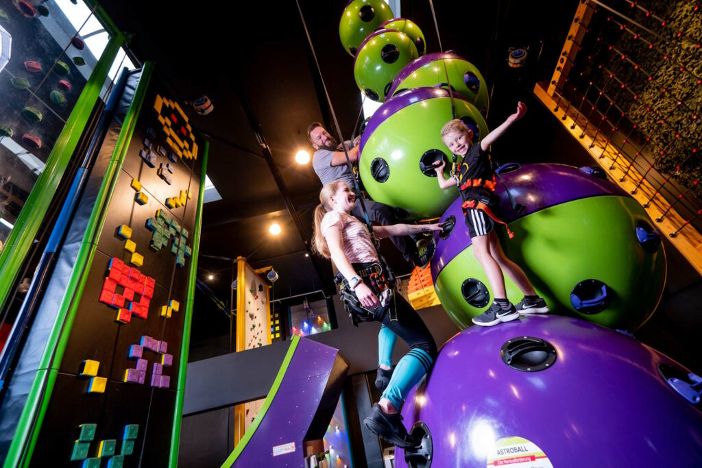 Mann und zwei Kindern beim Klettern im Clip n Climb