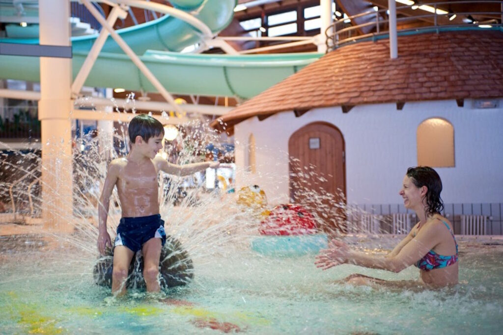 Kind und Mutter plantschen im Schwimmbad