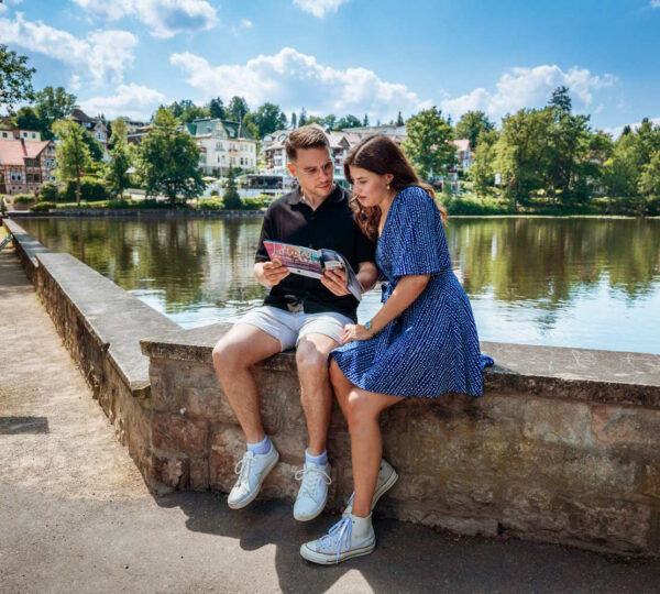 Paar sitzt auf Mauer am Schmelzteich