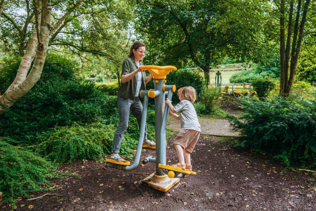 Mutter und Kind auf Fitnessgeräten im Vitalpark
