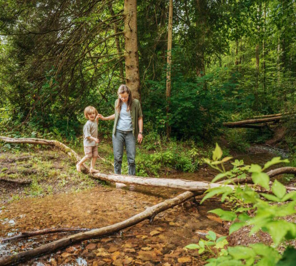 Mutter und Kind am Bachlauf im Wald