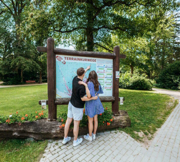 Paar steht vor der Infotafel der Terrainkurwege in Bad Sachsa