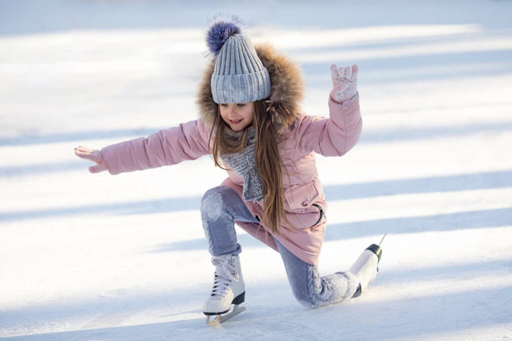 Mädchen in Pose auf einer Eislaufbahn.