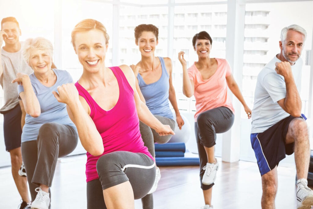 Lachende Gruppe beim Trainieren im Fitnesskurs.