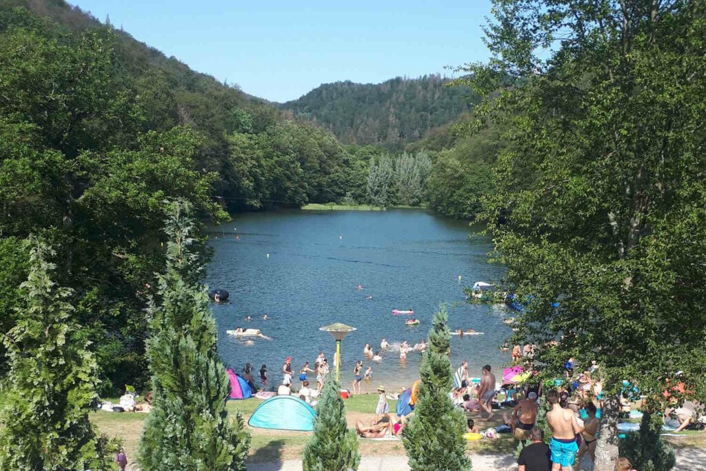 Wiesenbeker Teich mit Badegästen am Strandabschnitt.